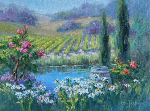 Peaceful pond surrounded by colorful flowers and vineyards in the background, with rolling hills beyond.