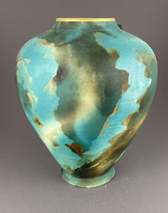 Backside of large cutout vase with cypress tree in cutout, soft teal and green vase with gold interior and lip.