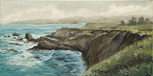 The Northern California Headlands covered in spring green grasses and an aqual blue sea in soft yellow morning light 