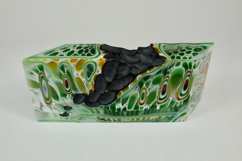 Earth 4, kiln formed glass sculpture, 8.25 inches long by 3.25 inches high by 1.75 inches deep. This lovely piece features kelly green, sage green, gold, white and clear glass colors with a black textured segment.
