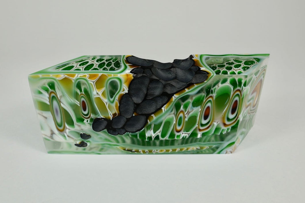 Earth 4, kiln formed glass sculpture, 8.25 inches long by 3.25 inches high by 1.75 inches deep. This lovely piece features kelly green, sage green, gold, white and clear glass colors with a black textured segment.