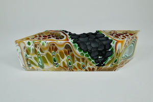 Earth 5, kiln formed glass sculpture, 9.75 inches long by 2.75 inches high by 1.75 inches deep.  This piece features leaf green, brown, white, gold and clear glass with a textured black segment.