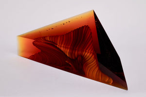  Water 1, kiln formed glass sculpture, 14.5 inches long by 6 inches high by 3.75 inches deep. This piece is in varying amber shades with a white interior.  The multiple angles create a unique shape.