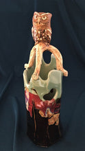 Load image into Gallery viewer, ceramic vase with branch and screech owl atop. Brown/black tenmoku and pale green celedon with red and gold glazes.
