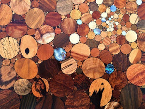 Over 100 kinds of wood and shell in a kaleidoscope effect of the big bang, detail of wood inlaid wall art piece. 