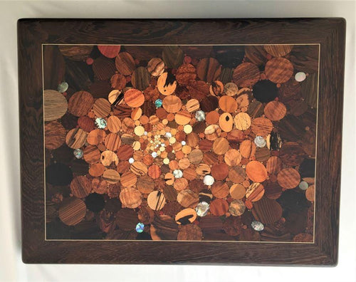 Over 100 kinds of wood and shell in a kaleidoscope effect of the big bang, framed in very deep dark wood with pale inlaid line. Wood inlay wall art .