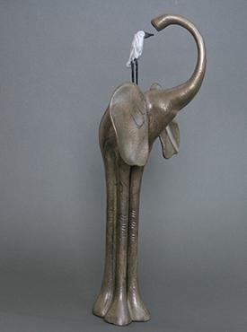 cast bronze curious long-legged elephant with her pal, a white egret, perched on her back. Bronze patina with black and white.