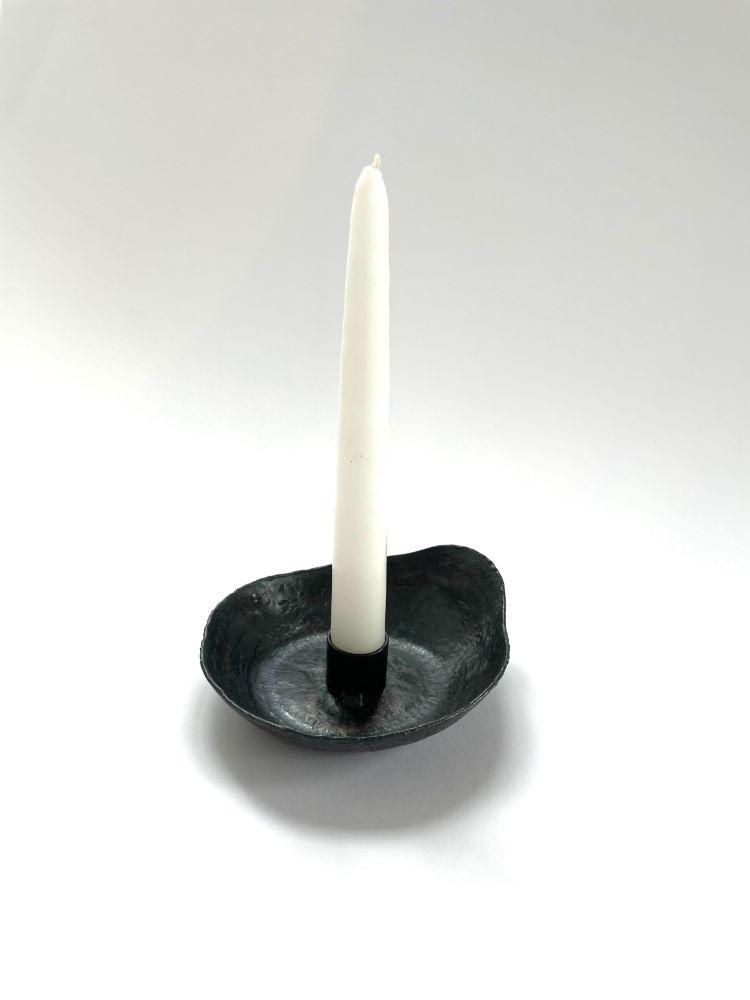 forged steel candleholder with raised sides hold one taper