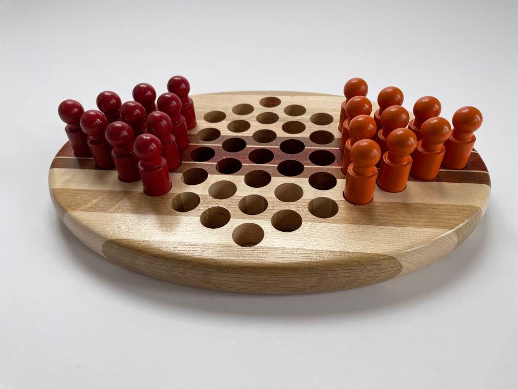 Hand-made Chinese Checkers for two. Painted pegs fit in the holes in the pieced board. Made of maple, oak, paduak, and walnu