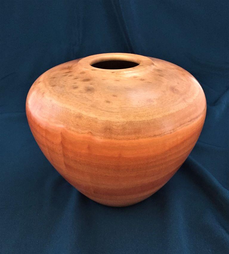 This redgum eucalyptus vessel, with lighter figured top and striped lower portion in deep red tones, is striking in form, color and figure.