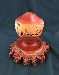 This unique turned vase has a fractal burned design over the light sapwood and a natural edge base, all of one piece.The design shows the bark and layers of inner bark, cambium and sapwood. 