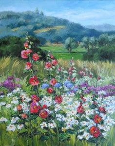 A profusion of blooms, pink-red hollyhocks, white and yellow daisies, with touches of blue and purple, and looking back to green fields and gentle hills.