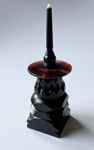 turned top and stand, intricate patterns on blackwood stand with acetate top body and tagua nut tip of top.