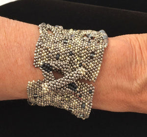 textural beaded cuff bracelet in silver and irridecent blues, post and diamond shaped closure