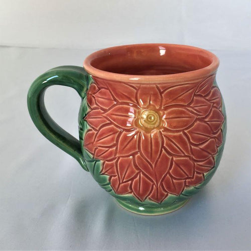 mug with carved flower and leaves, in brilliant coral and green