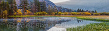 Load image into Gallery viewer, Fall colors surround the lake and mountains are reflected in the still water
