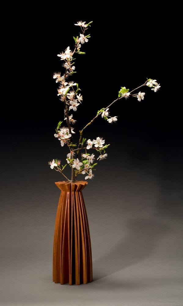 Poppy vase of cherry wood, one piece of wood, cut and opened up to create a graceful form. With glass tube for water and flowers