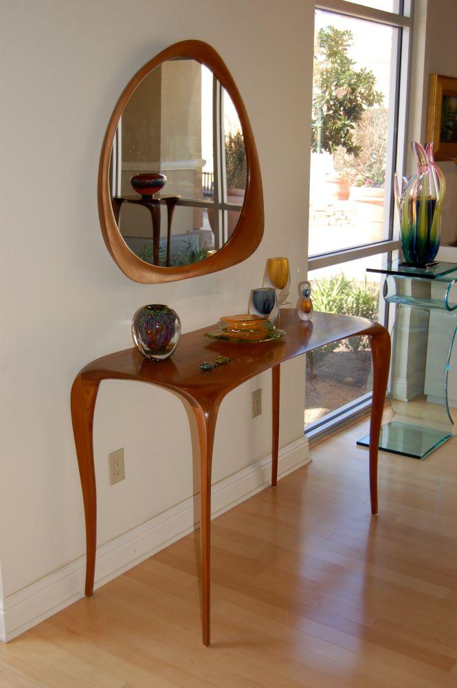 carved console table and free-form mirror