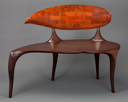 teardrop shaped back and seat of carved wenge and African mahogany bench